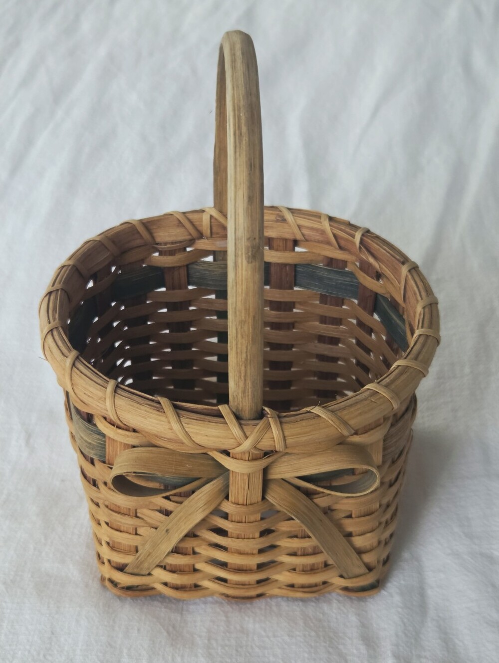 Vintage, Hand-Woven Basket Featuring A Unique Bow Detail And Green Accent